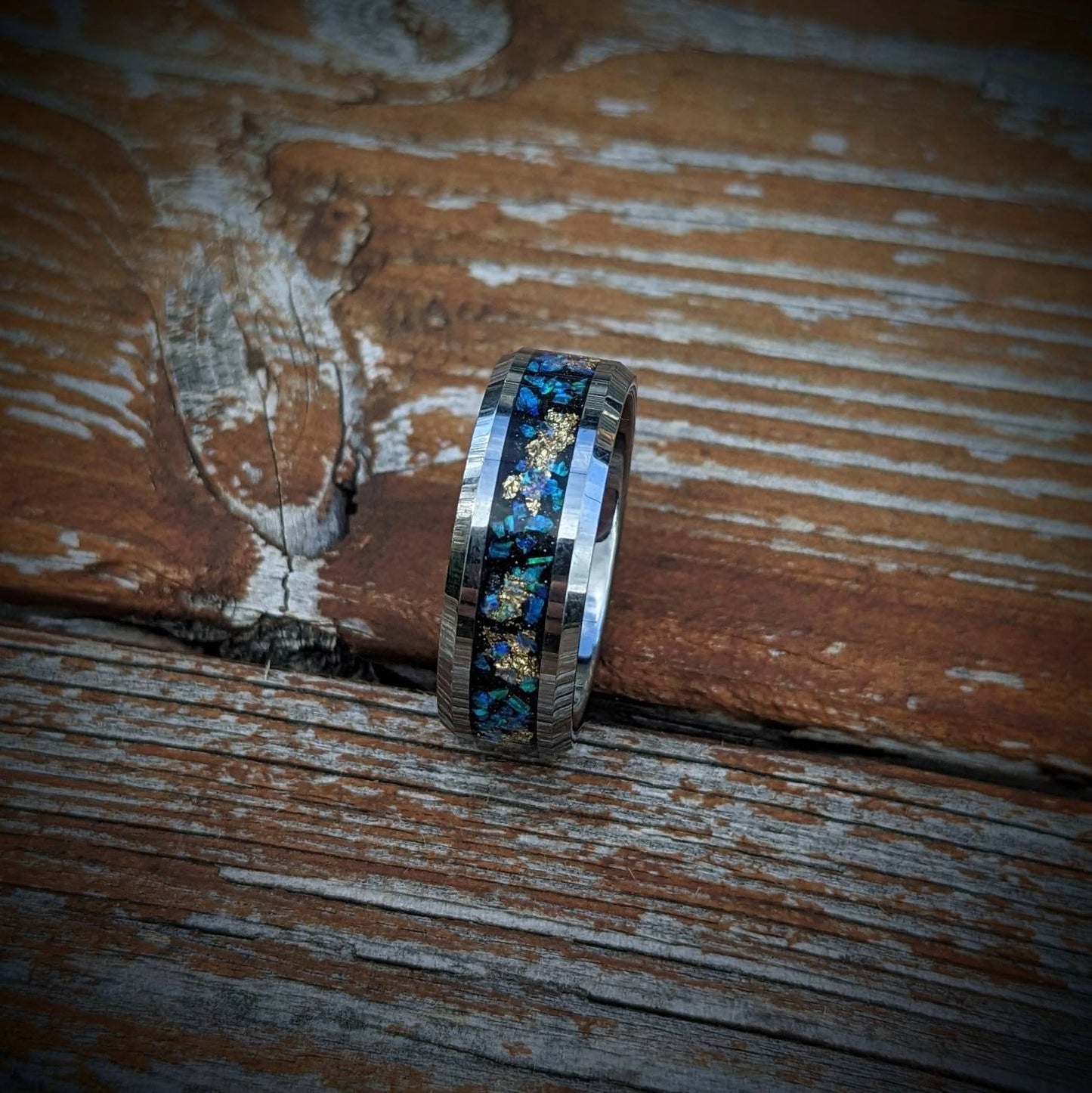 Embrace the cosmos with this beautifully crafted galaxy-inspired ring, featuring a high-polished tungsten band inlaid with radiant blue opals and fine gold leaf. The opals create a dazzling, galaxy-like display, symbolizing wonder and infinite possibilities. Designed for exceptional comfort and long-lasting wear, this ring is scratch-resistant and eye-catching. It’s the perfect piece for those who want jewelry that tells a story and captures the magic of the stars.