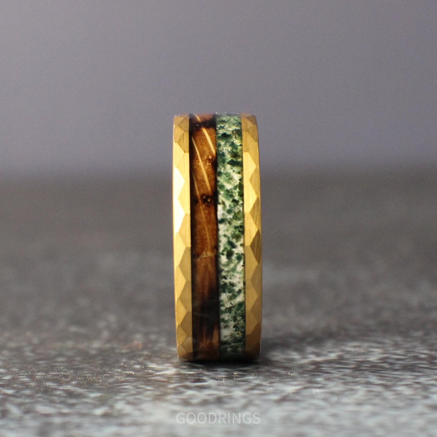 Gold wedding ring with hammered edges, inlaid with half whiskey barrel wood and half moss agate; rustic yet elegant design for men or women.