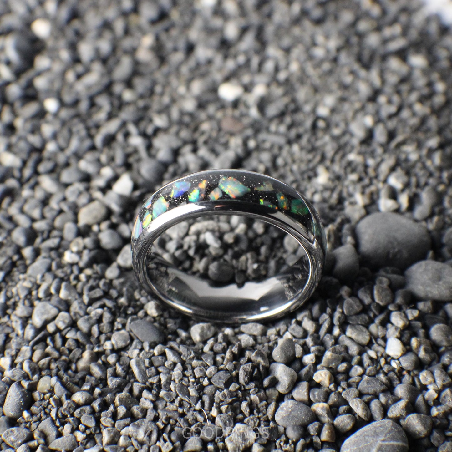 A polished silver ring, 6mm wide, featuring a black inlay layered with shimmering white opals.