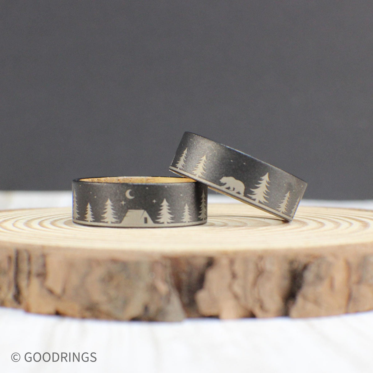 Stylish and rugged men’s wedding band with a detailed outdoor engraving on tungsten and a whiskey barrel wood interior, perfect for nature lovers.