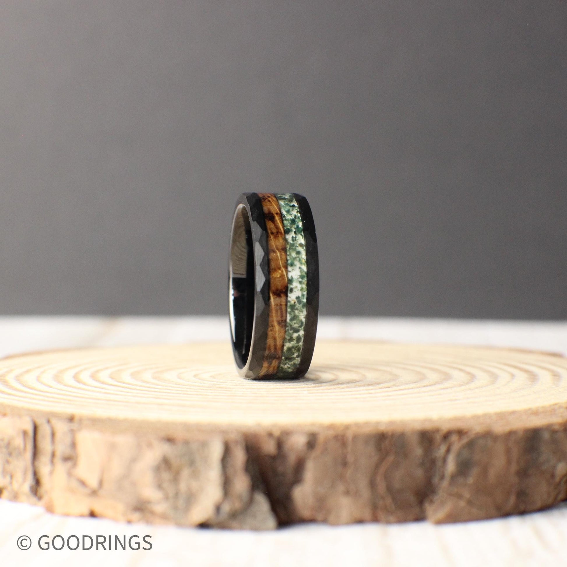 This bold tungsten ring showcases a unique mix of charred whiskey barrel wood and vibrant moss agate, symbolizing strength, tradition, and nature.