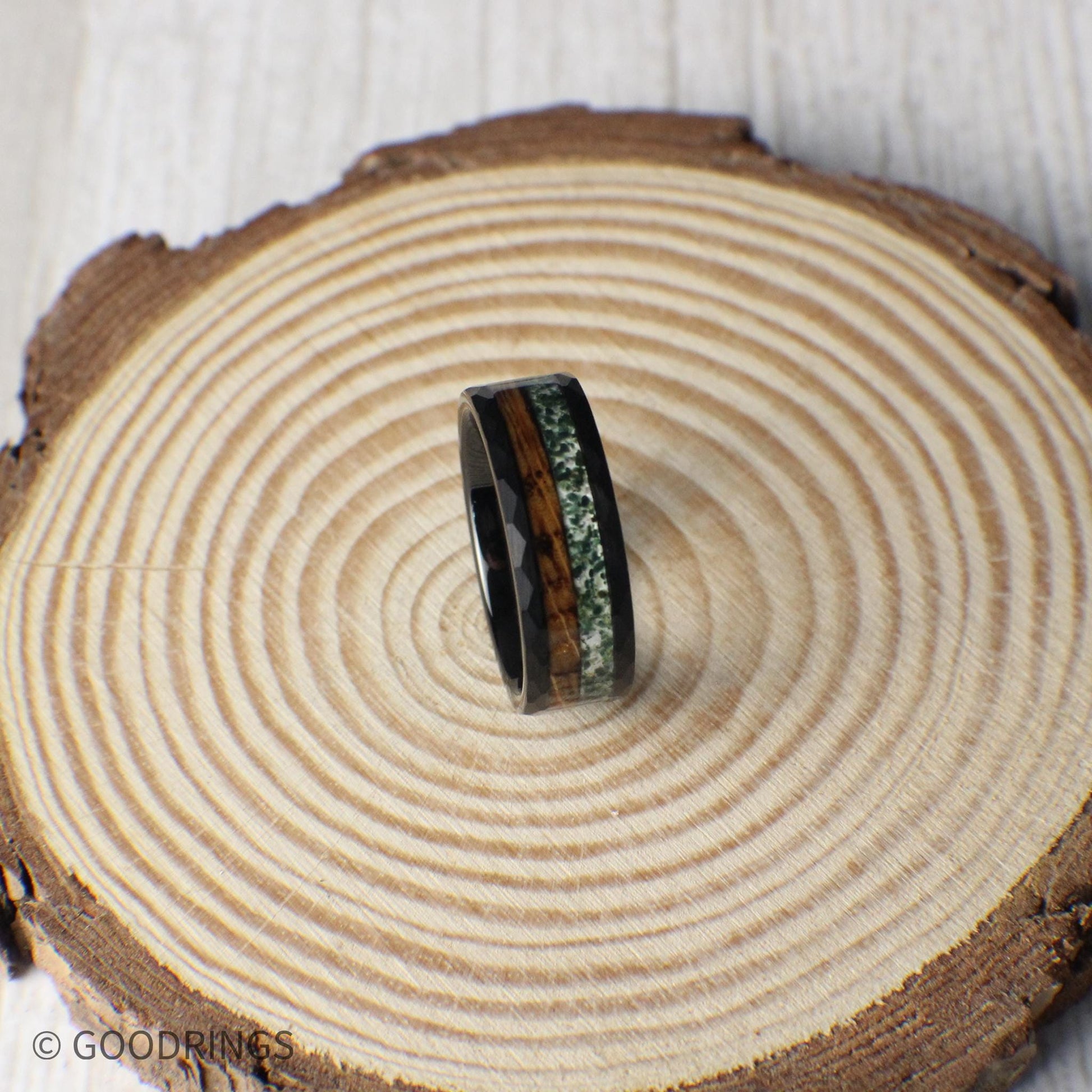 A striking 8mm black hammered tungsten band with contrasting inlays of deep-charred whiskey barrel wood and earthy crushed moss agate.