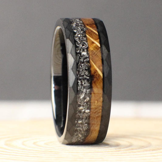An 8mm hammered tungsten ring with a dual inlay of burnt whiskey barrel wood and genuine Muonionalusta meteorite, blending rugged earthiness with cosmic wonder.