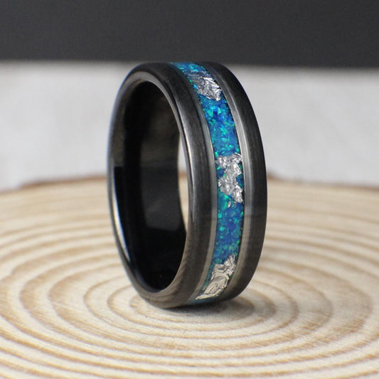 Aquamarine opal tungsten ring with silver leaf inlay. Vibrant blue and green hues reflect ocean beauty, framed by polished silver lines for contrast. Perfect as a wedding band or gift.