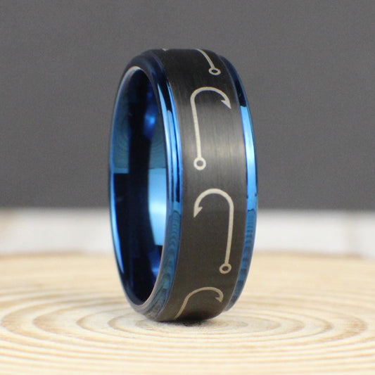 A sleek black brushed tungsten ring with engraved fishing hooks wrapping around the entire 8mm band. The deep blue interior and edges provide a striking contrast, making this a perfect fishing gift for men. Comfort fit design ensures all-day wearability. Comes with a premium green and gold ring box, a gift box, a ring sizer, and a free silicone ring. Free resizing and returns available.