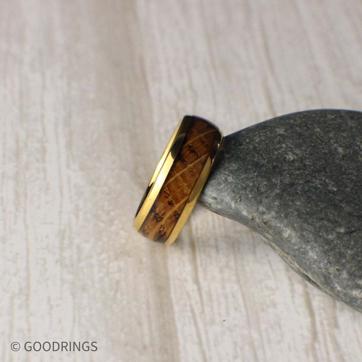 A handcrafted men’s wedding band with a golden tungsten core and a striking inlay of reclaimed whiskey barrel wood. The domed design and polished finish reflect a perfect blend of rugged tradition and contemporary style, ideal for everyday wear.
