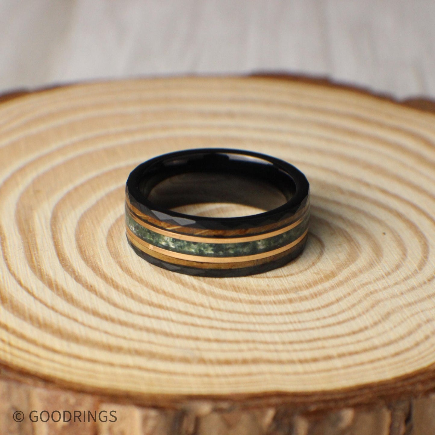 Unique hammered tungsten ring in black, measuring 8mm wide with an eye-catching inlay combination of moss agate, 18K rose gold, and whiskey barrel wood. Each element adds depth and meaning—the moss agate symbolizes growth, the rose gold conveys warmth, and the whiskey barrel wood reflects history and tradition. Strong, stylish, and meaningful, this ring makes a statement for weddings or special milestones.