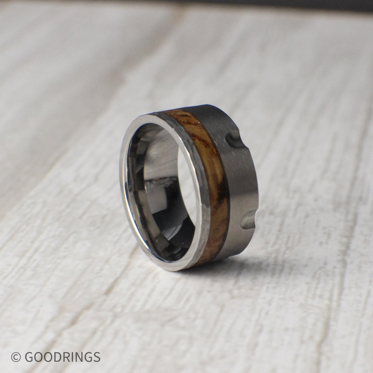 A 10mm tungsten ring that merges industrial design with rustic heritage, featuring revolver-inspired grooves and a charred whiskey barrel wood inlay. The brushed tungsten finish delivers strength and durability, while the whiskey wood adds warmth and depth. This comfort-fit band is an ideal choice for weddings, anniversaries, or as a distinctive accessory for someone who appreciates bold, meaningful jewelry.