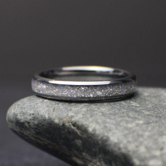 top view of minimalist 4mm moonstone band resting on stone highlighting subtle shimmer and comfort fit design