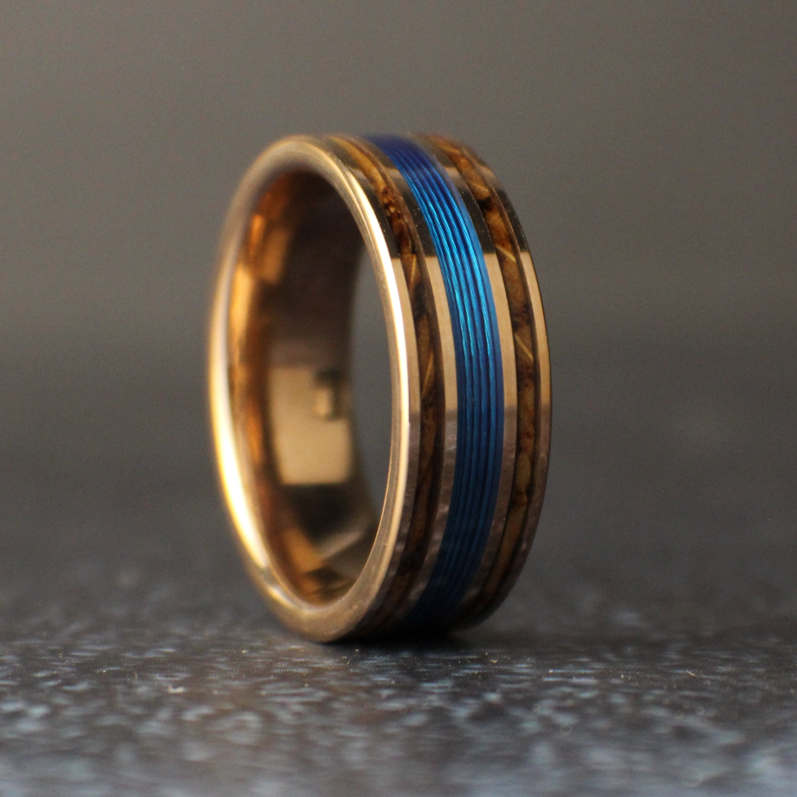 Gold ring with a blue inlay on a dark gray background