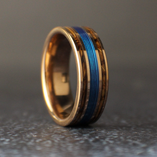 Gold ring with a blue inlay on a dark gray background
