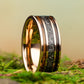 Gold and black ring on a mossy surface with a blurred natural background
