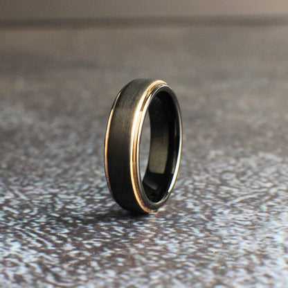 Tungsten wedding ring with a brushed finish and rose gold edges.