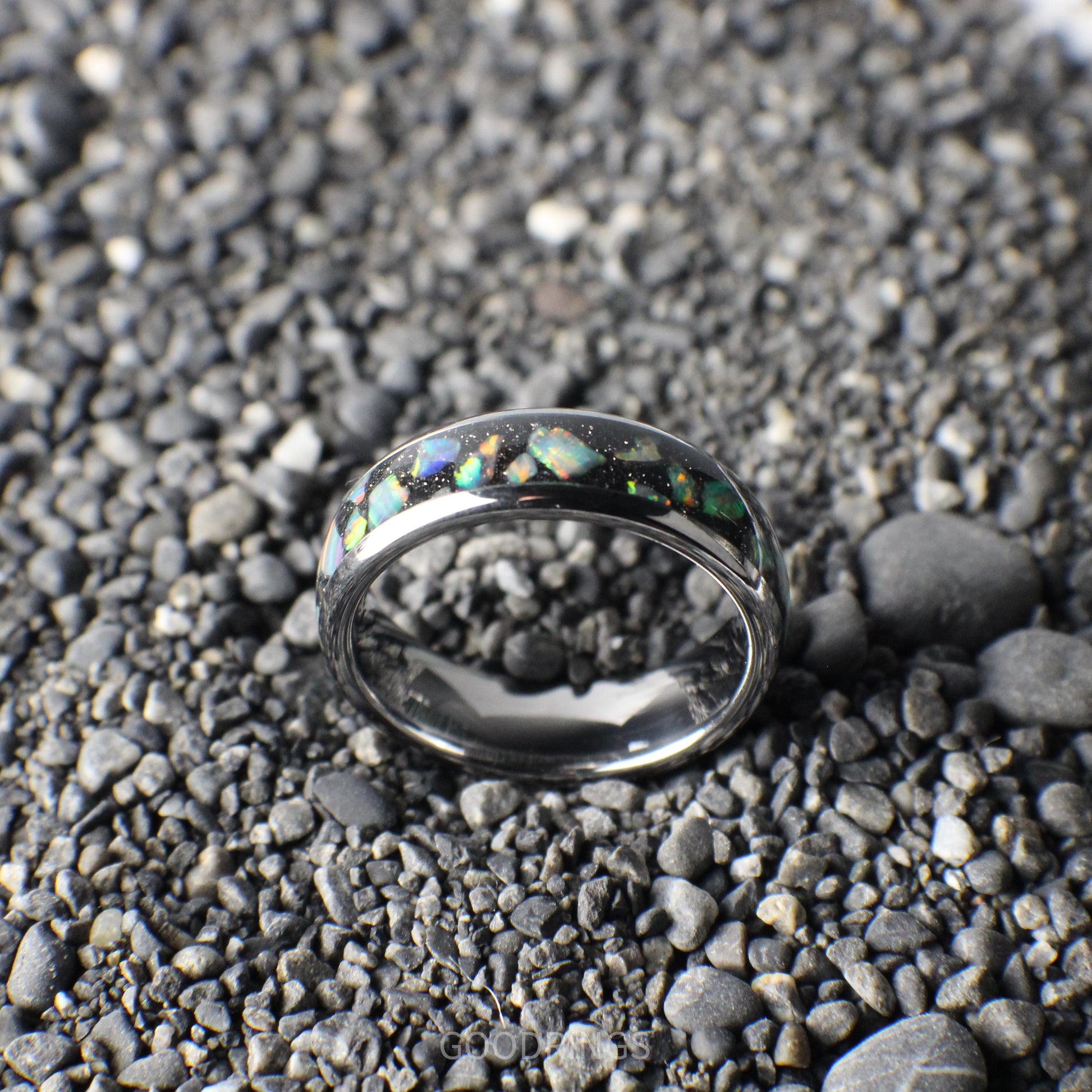 A polished silver ring, 6mm wide, featuring a black inlay layered with shimmering white opals.