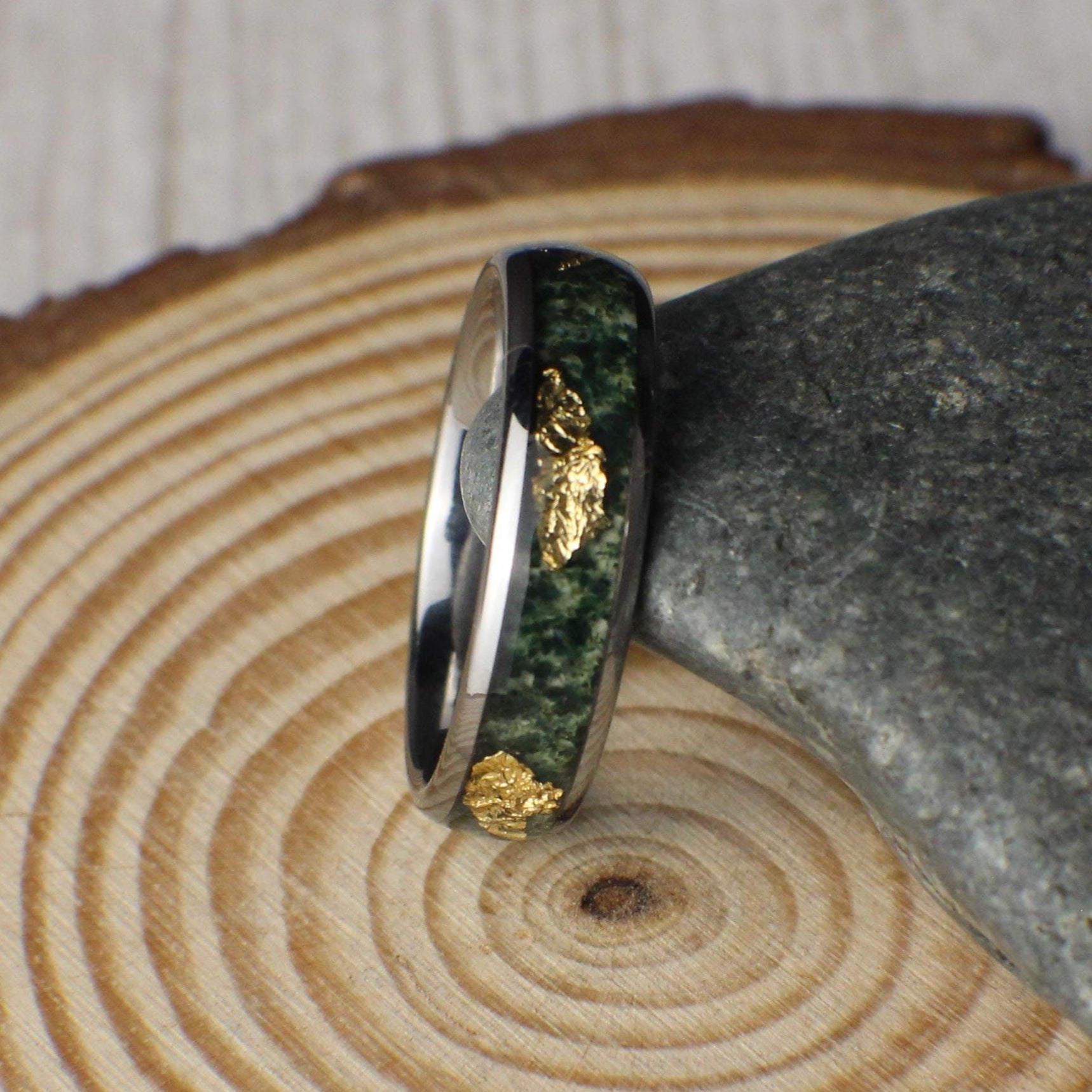 A 6mm tungsten ring featuring a polished finish with an inlay of vibrant moss agate and shimmering gold leaf, blending natural elegance with modern durability.
