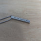 Close-up of a rectangular stainless steel bar pendant with a brushed finish, hanging from a sleek 22-inch box chain, customizable with meaningful engravings.