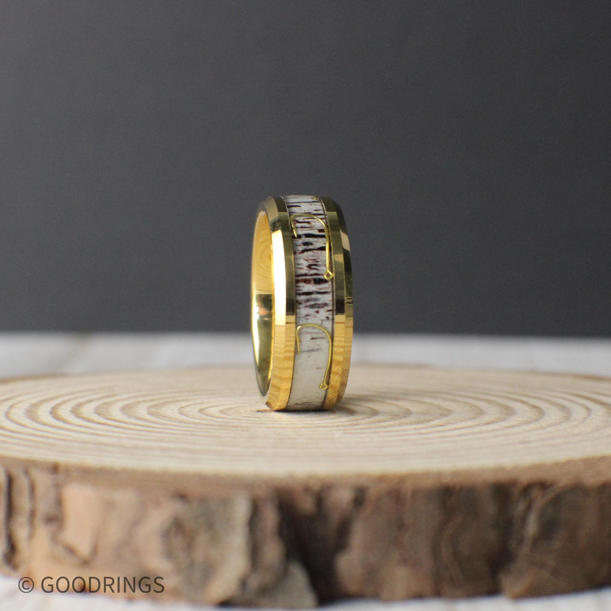This gold-plated tungsten ring showcases real antler inlay with a striking fishing hook accent, blending rugged charm with refined style.