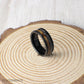 A rugged yet refined 8mm hammered tungsten ring with whiskey barrel wood and real meteorite, connecting the wearer to both craftsmanship and deep space.
