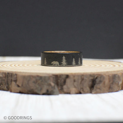 Wedding ring highlighting the intricate forest engraving on durable tungsten and the rich whiskey wood lining inside.