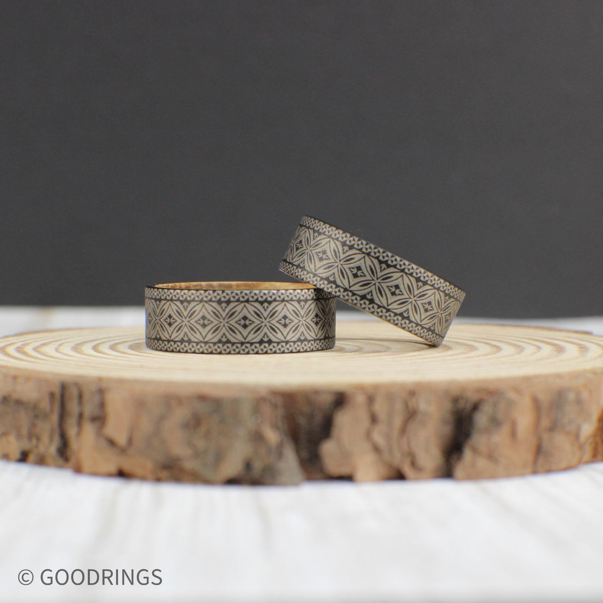 8mm tungsten wedding band showcasing a fully engraved Polynesian pattern with a smooth whiskey barrel wood lining inside.