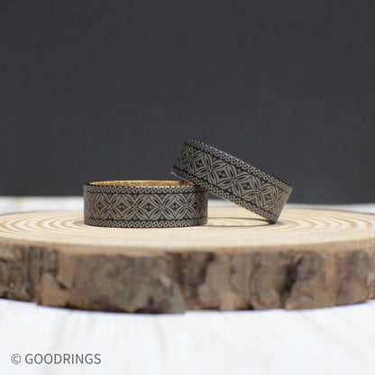 Durable tungsten ring with a Polynesian engraving symbolizing strength and tradition, complemented by a whiskey barrel wood core.