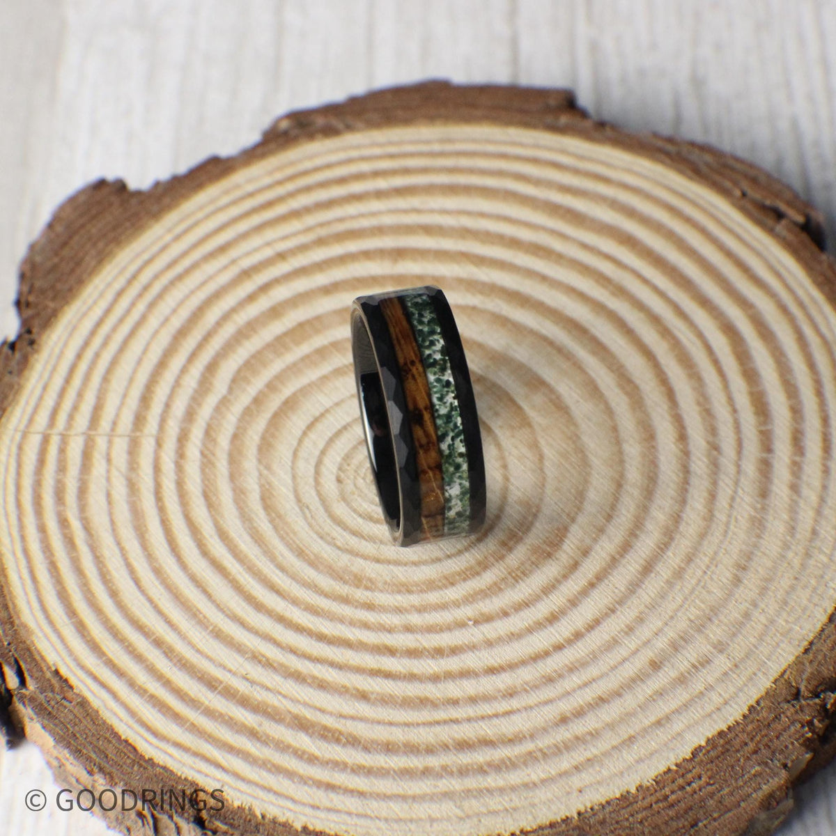 A striking 8mm black hammered tungsten band with contrasting inlays of deep-charred whiskey barrel wood and earthy crushed moss agate.