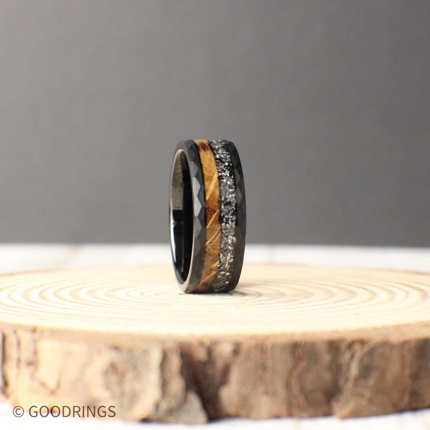 This bold tungsten ring features a hammered finish, half-burnt whiskey barrel wood, and genuine meteorite inlay, symbolizing strength and the universe’s mystery.