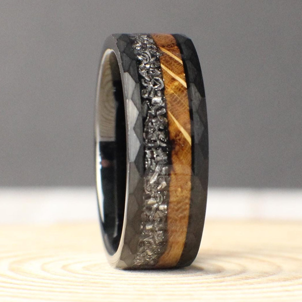 An 8mm hammered tungsten ring with a dual inlay of burnt whiskey barrel wood and genuine Muonionalusta meteorite, blending rugged earthiness with cosmic wonder.