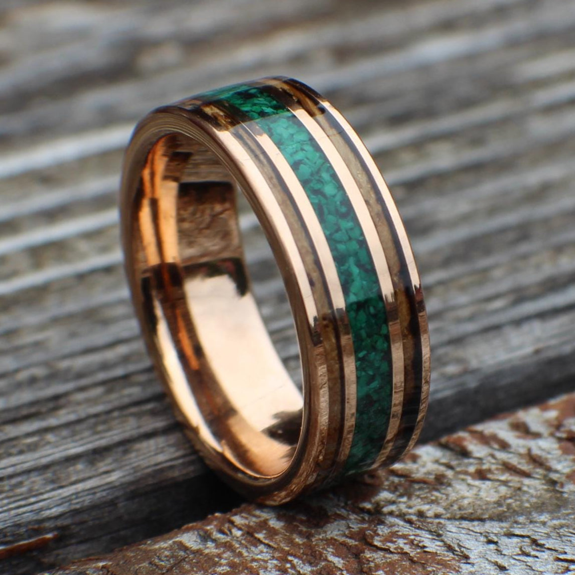 Rose gold tungsten ring with charred whiskey barrel and crushed malachite inlay. The warm tones of wood contrast beautifully with vivid green malachite, symbolizing transformation and strength. Perfect for weddings or special occasions.