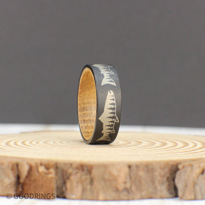 Nature-inspired tungsten ring featuring a salmon engraving with a tree line inside, complemented by a whiskey wood liner.