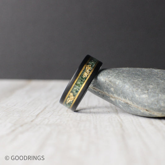 Black tungsten ring featuring a moss agate inlay with unique patterns and delicate gold leaf accents, bordered by gold lines for a refined finish. Includes a gift box, ring sizer, and silicone ring, with lifetime warranty and free exchanges.