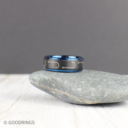 An expertly crafted black tungsten ring with engraved fishing hooks that wrap around the 8mm band. The deep blue interior and edges add a striking contrast, making it a unique gift for fishermen and outdoor lovers. This comfort-fit ring is perfect for everyday wear or special occasions. Comes in a green and gold ring box inside a gift box, with a ring sizer and a free silicone ring included. Free resizing and returns for worry-free shopping.