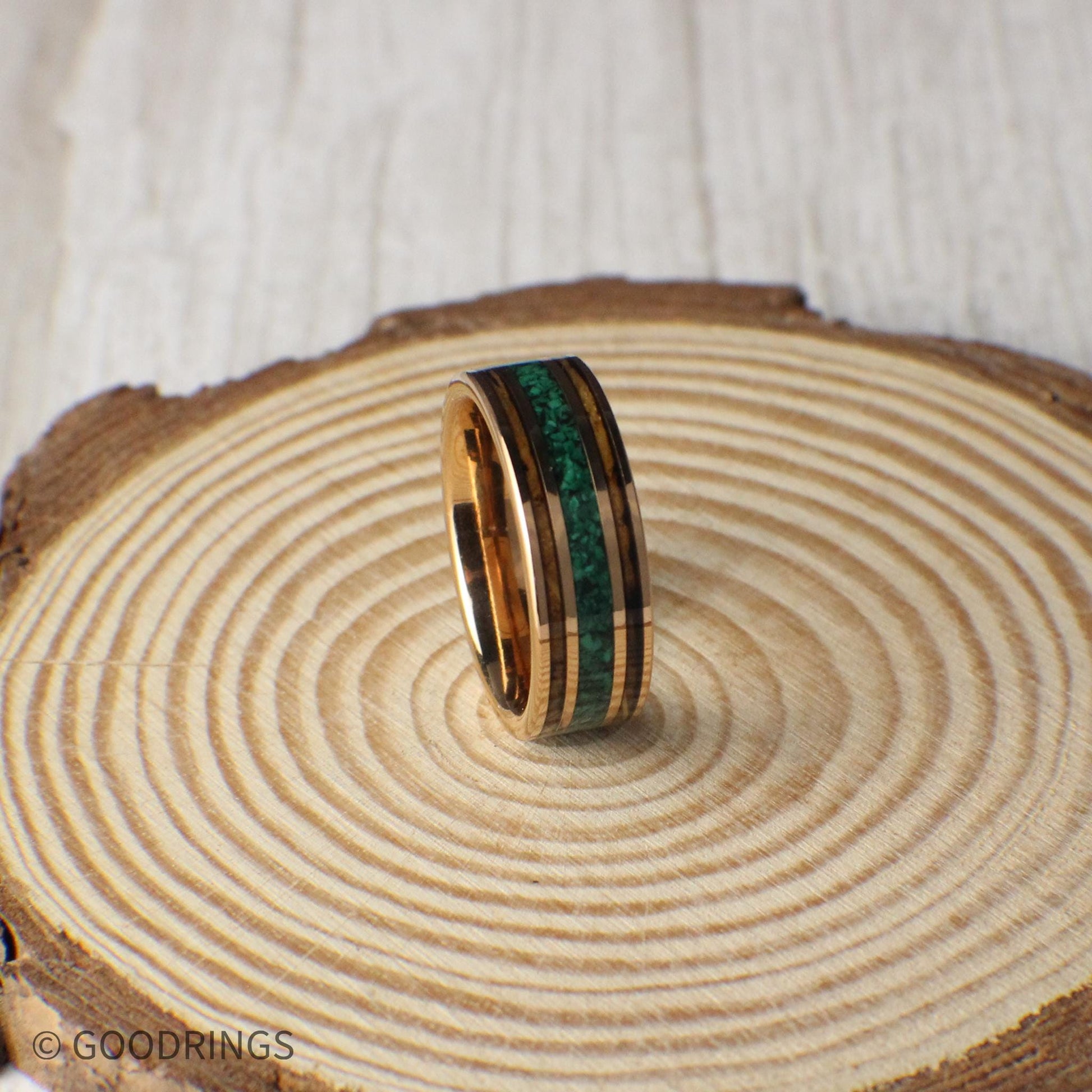 Durable rose gold tungsten ring with charred whiskey barrel wood and a center line of crushed malachite. A perfect blend of elegance and natural charm, ideal for weddings or gifts.