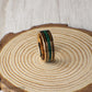 Durable rose gold tungsten ring with charred whiskey barrel wood and a center line of crushed malachite. A perfect blend of elegance and natural charm, ideal for weddings or gifts.