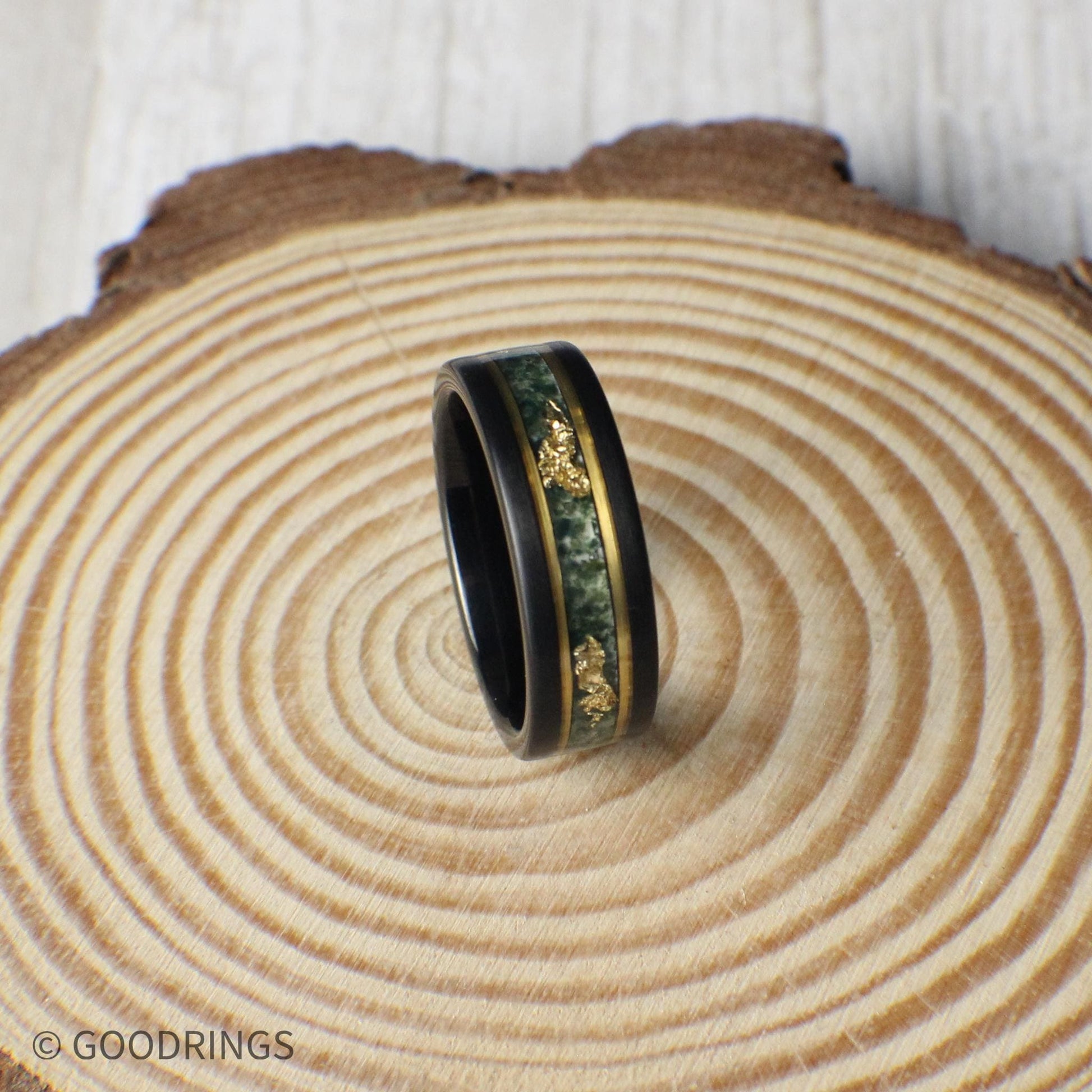 Striking 8mm black tungsten ring with moss agate and gold leaf inlay, bordered by gold lines for added elegance. Includes a gift box, silicone ring, and ring sizer. Covered by a lifetime warranty with free exchanges and easy returns.