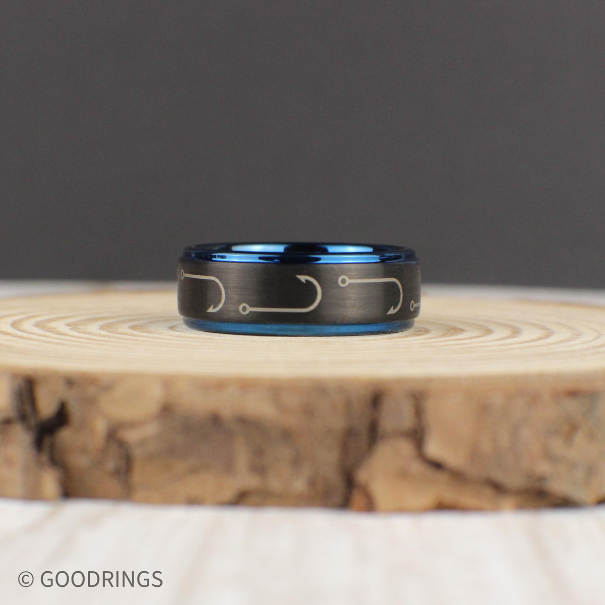 This engraved fishing hook ring features a rugged black brushed tungsten exterior with detailed fishing hooks encircling the band. The vibrant dark blue interior and edges create a bold contrast. Designed for comfort, this 8mm wedding band is perfect for fishermen, outdoorsmen, and those who love the water. Comes in a gift-ready green and gold ring box with a ring sizer and silicone ring included.