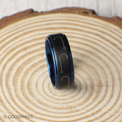 This unique tungsten ring features a brushed black finish with intricately engraved fishing hooks wrapping around the 8mm band. The deep blue interior and edges offer a bold contrast. Perfect as a wedding band, promise ring, or a special fishing-themed gift. Comes in a luxurious green and gold ring box inside a gift box, with a ring sizer and silicone ring included. Custom engraving available.