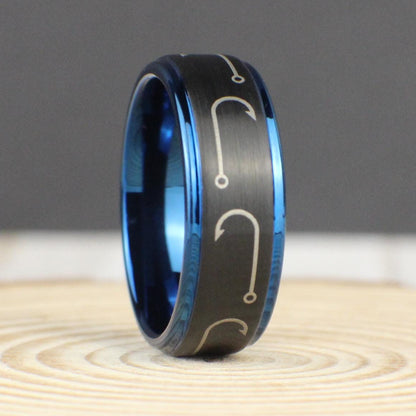 A sleek black brushed tungsten ring with engraved fishing hooks wrapping around the entire 8mm band. The deep blue interior and edges provide a striking contrast, making this a perfect fishing gift for men. Comfort fit design ensures all-day wearability. Comes with a premium green and gold ring box, a gift box, a ring sizer, and a free silicone ring. Free resizing and returns available.