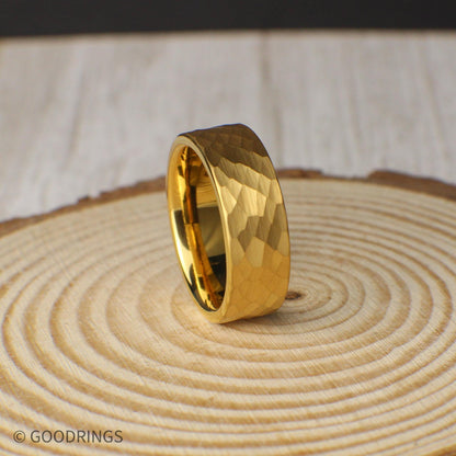 Close-up of an 18K gold plated tungsten ring, 8mm wide with a distinctive hammered finish. Designed for men or women who prefer subtle sophistication and long-lasting quality. The gold plating adds warmth to the rugged texture, while the included silicone band and ring box enhance the overall value. Lifetime warranty, free returns, and exchanges make this an easy, confident choice.