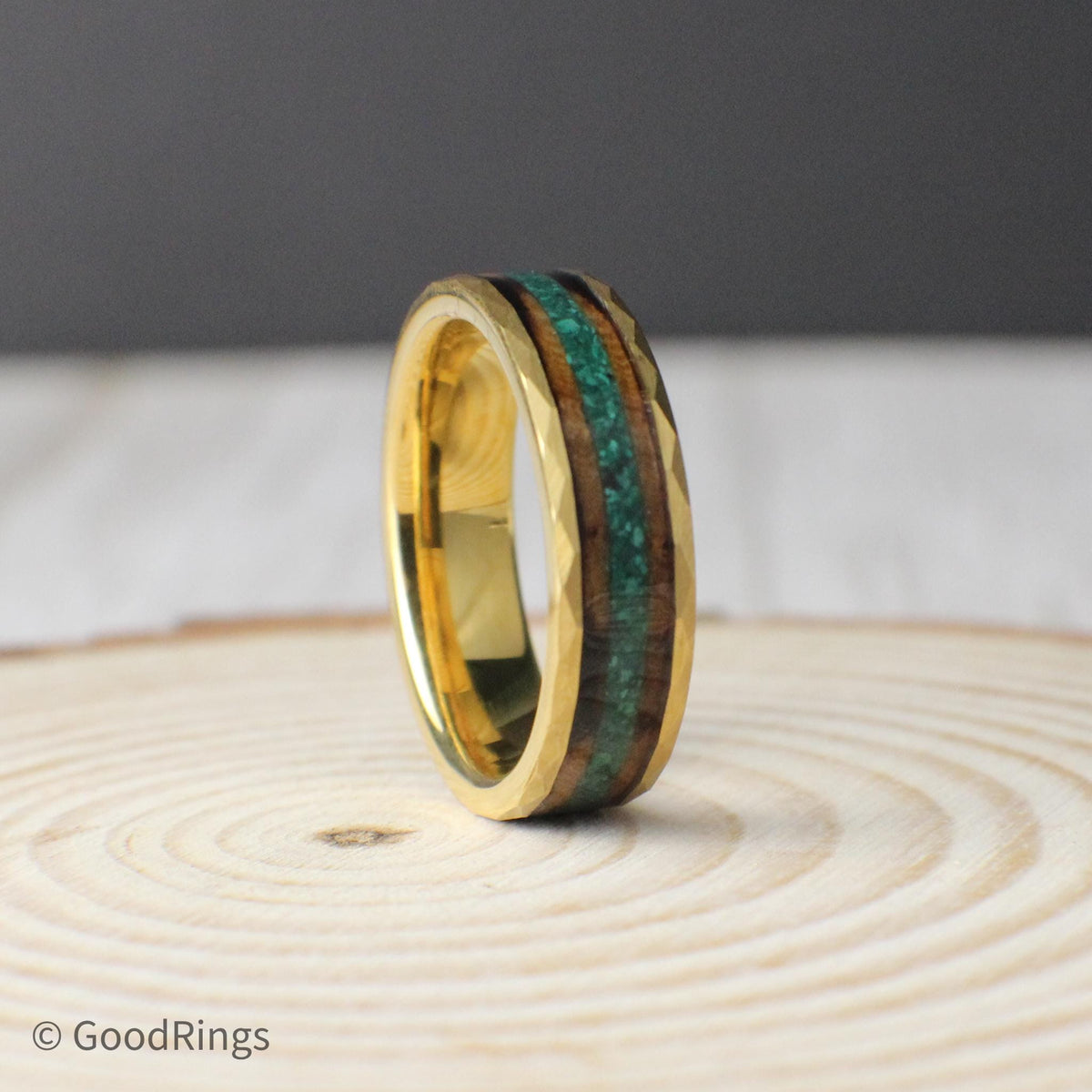 An 8mm or 6mm wide tungsten ring with a hammered gold-plated surface, paired with a dual inlay design. The ring features a warm, textured strip of burnt whiskey barrel wood, complemented by a center line of crushed moss agate for a vibrant, earthy contrast. The hammered texture gives the band a handcrafted, masculine feel, making it a great fit for nature lovers or anyone looking for something unique.