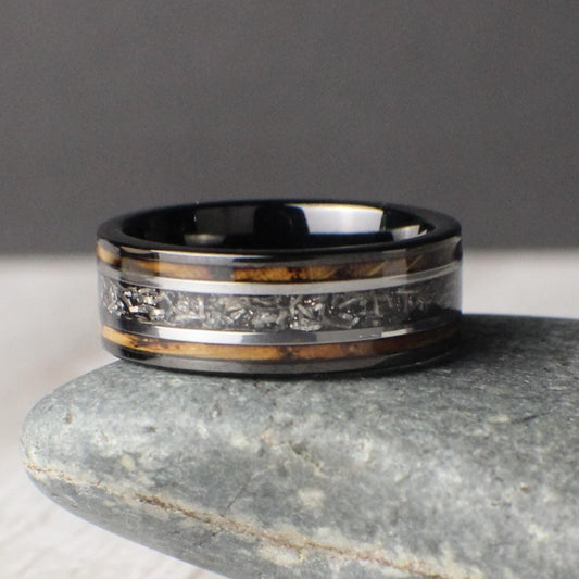 This 8mm tungsten ring is a powerful wedding or anniversary band featuring a burnt whiskey barrel wood inlay with a striking meteorite center line. Silver accents on either side of the meteorite add contrast and detail, creating a refined and symbolic design. A durable and meaningful choice for weddings, promises, or gift-giving, this ring blends natural warmth with space-born material in a unique and lasting statement.