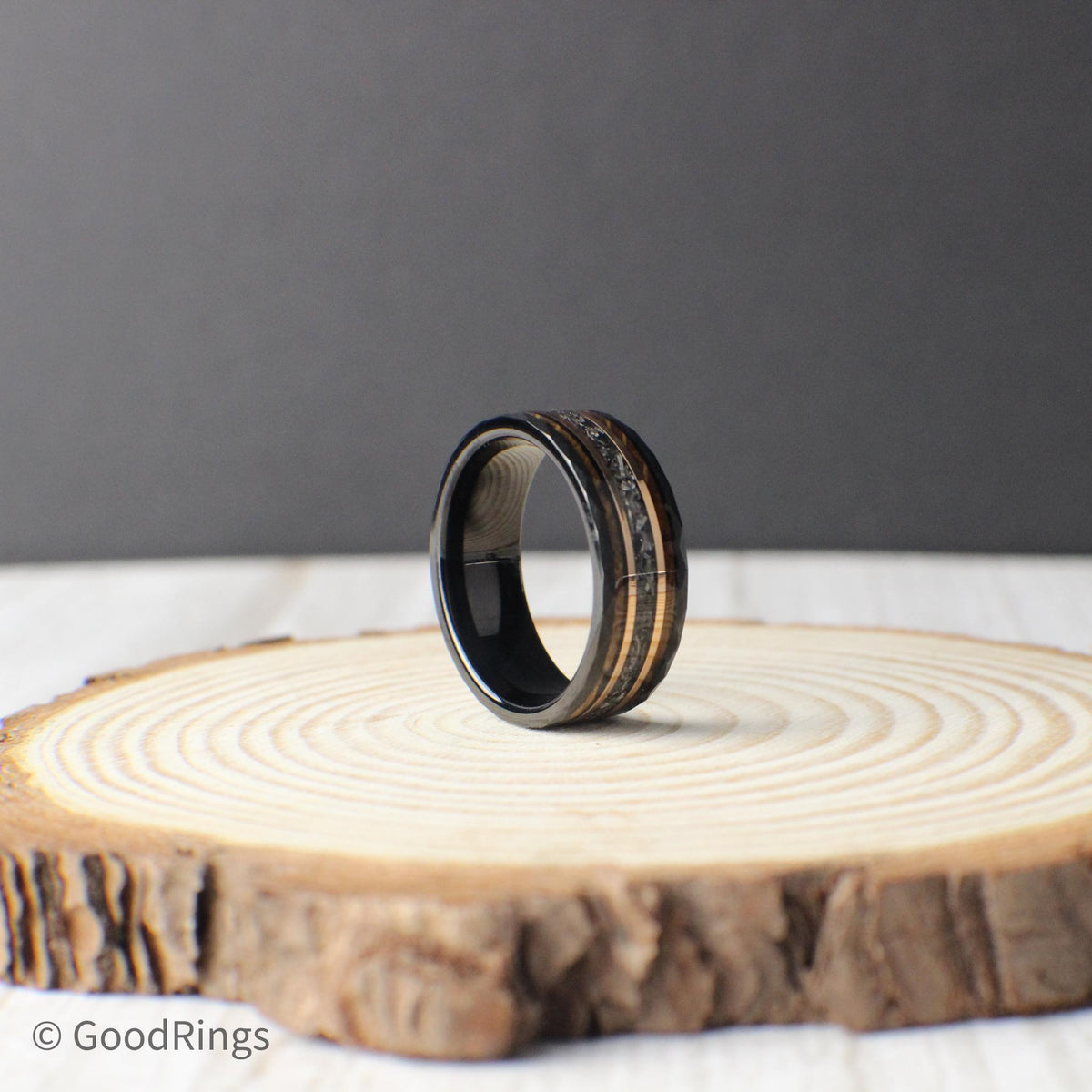 A unique tungsten ring for men featuring a hammered black finish, real meteorite inlay, and contrasting borders of rose gold and whiskey barrel wood. The design blends rugged and refined elements, making it ideal as a wedding ring, anniversary present, or heirloom-quality statement piece. Crafted for everyday wear and built to last, this ring symbolizes both strength and story.