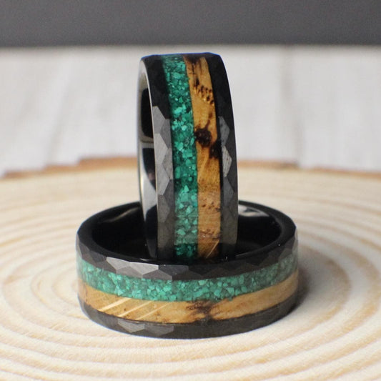 A rugged 8mm tungsten ring with a hammered exterior and a unique dual inlay on the inside. One half of the inlay features vibrant crushed malachite, while the other half showcases warm, charred whiskey barrel wood. This ring combines natural textures with a durable metal, offering a bold, earthy design that stands out. Ideal for those who want a ring that blends strength, style, and a touch of rustic character.