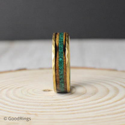A bold and earthy tungsten ring with a gold-plated hammered exterior and a detailed inlay. Burnt whiskey barrel wood lines the inside, offering a rich, rustic tone. Down the center, a crushed moss agate strip adds a pop of green and natural texture. Available in 6mm and 8mm widths, this ring is built for anyone who loves the combination of refined metal and rugged, organic materials.