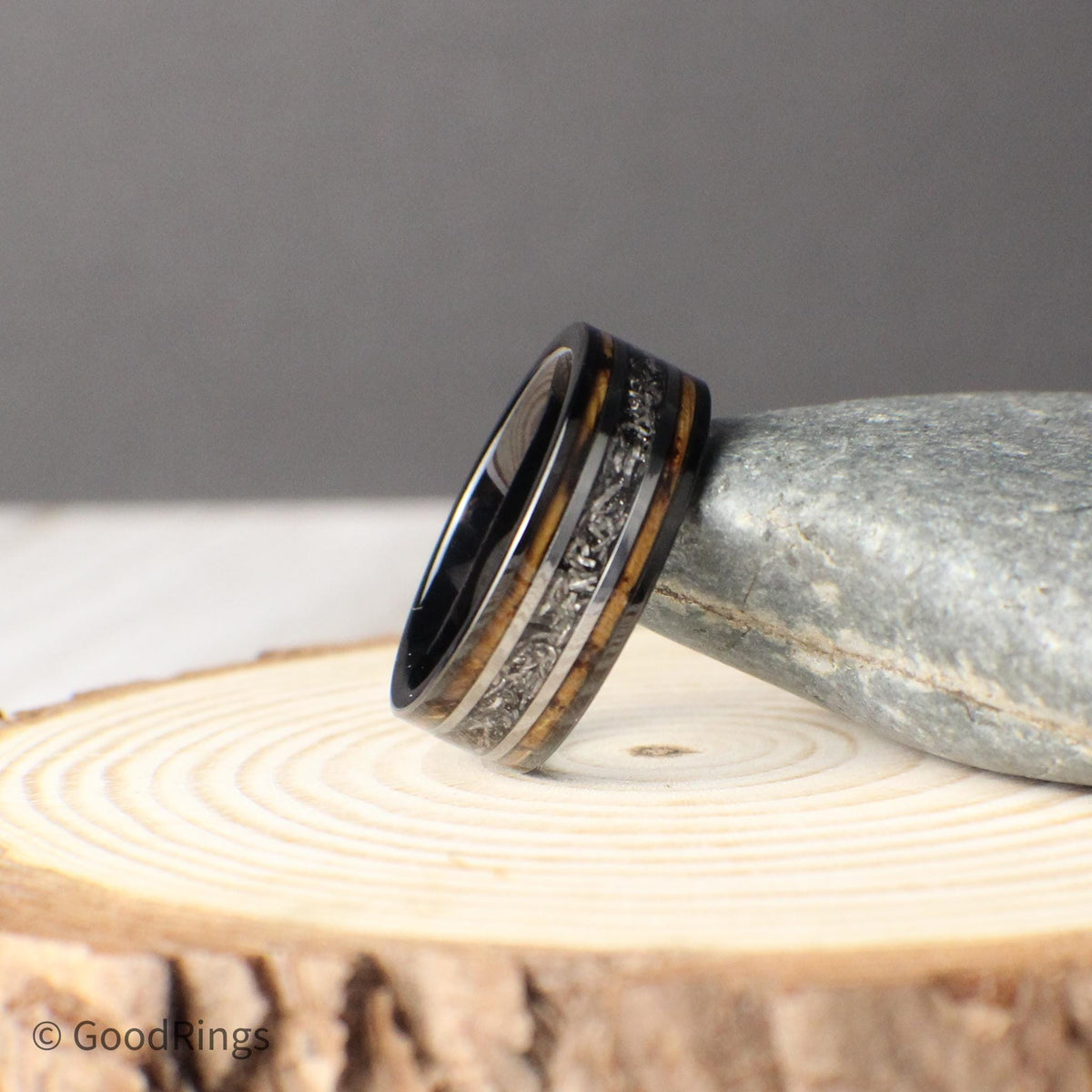 An 8mm tungsten wedding band featuring rich burnt whiskey barrel wood inlay, divided by a center line of genuine meteorite. Framed with silver accent lines, the meteorite adds a unique, cosmic element to this earthy and rugged design. Crafted for weddings, anniversaries, or special milestones, this ring offers both durability and deep symbolism, perfect for the man who values strength, style, and meaning.
