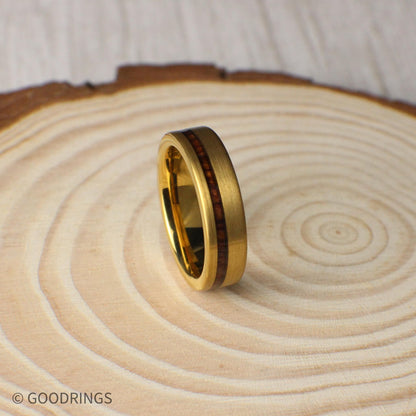 A detailed shot of the 6mm gold tungsten wedding band showing its brushed matte surface and contrasting organic wood inlay. The ring’s subtle sheen and natural materials make it a standout piece for men who want something unique and durable.