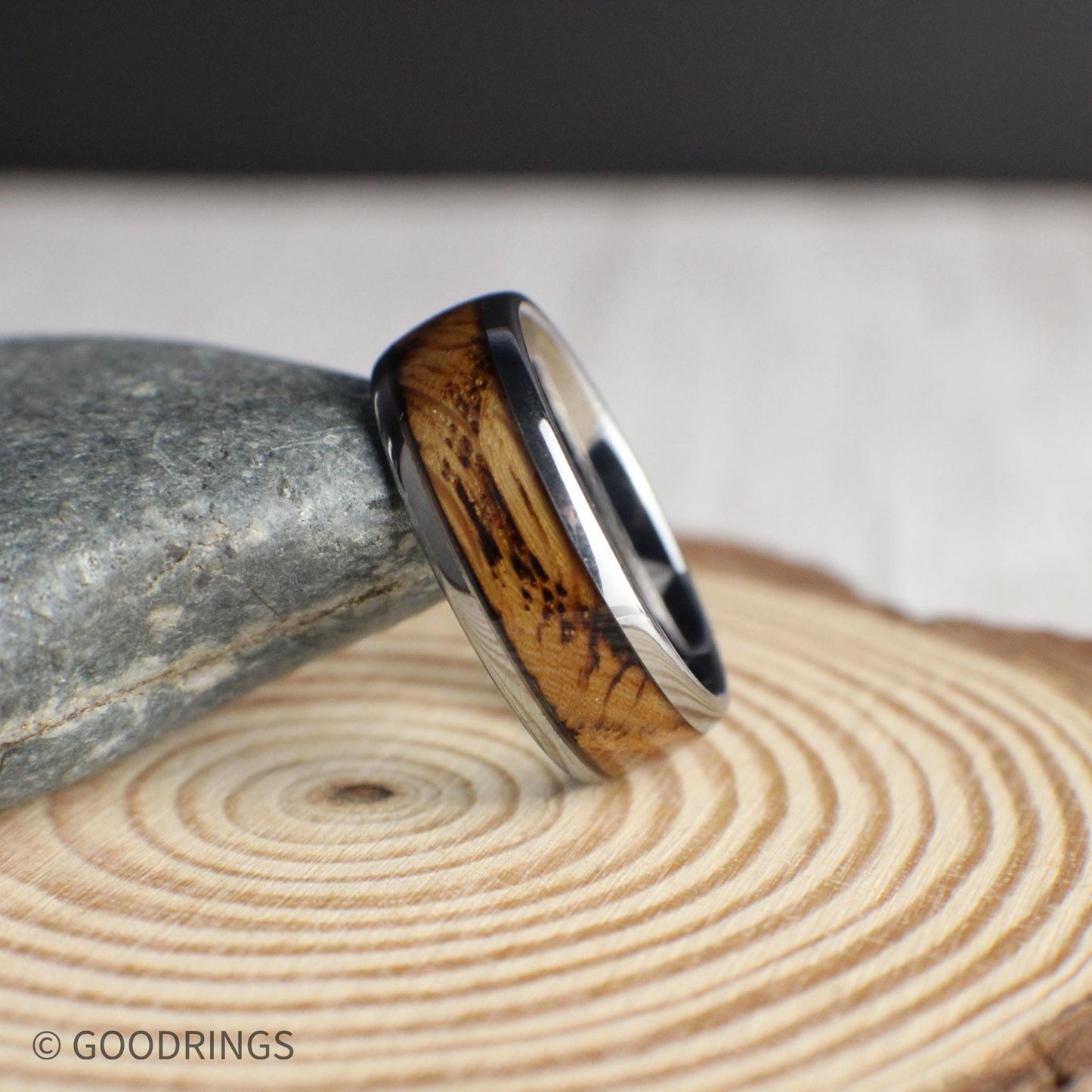 A unique 8mm tungsten men’s ring with a domed silhouette and a strip of authentic whiskey barrel wood. The smooth metal surface and natural wood detail make this band both rugged and refined—ideal for weddings, gifts, or everyday wear.