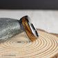 A unique 8mm tungsten men’s ring with a domed silhouette and a strip of authentic whiskey barrel wood. The smooth metal surface and natural wood detail make this band both rugged and refined—ideal for weddings, gifts, or everyday wear.