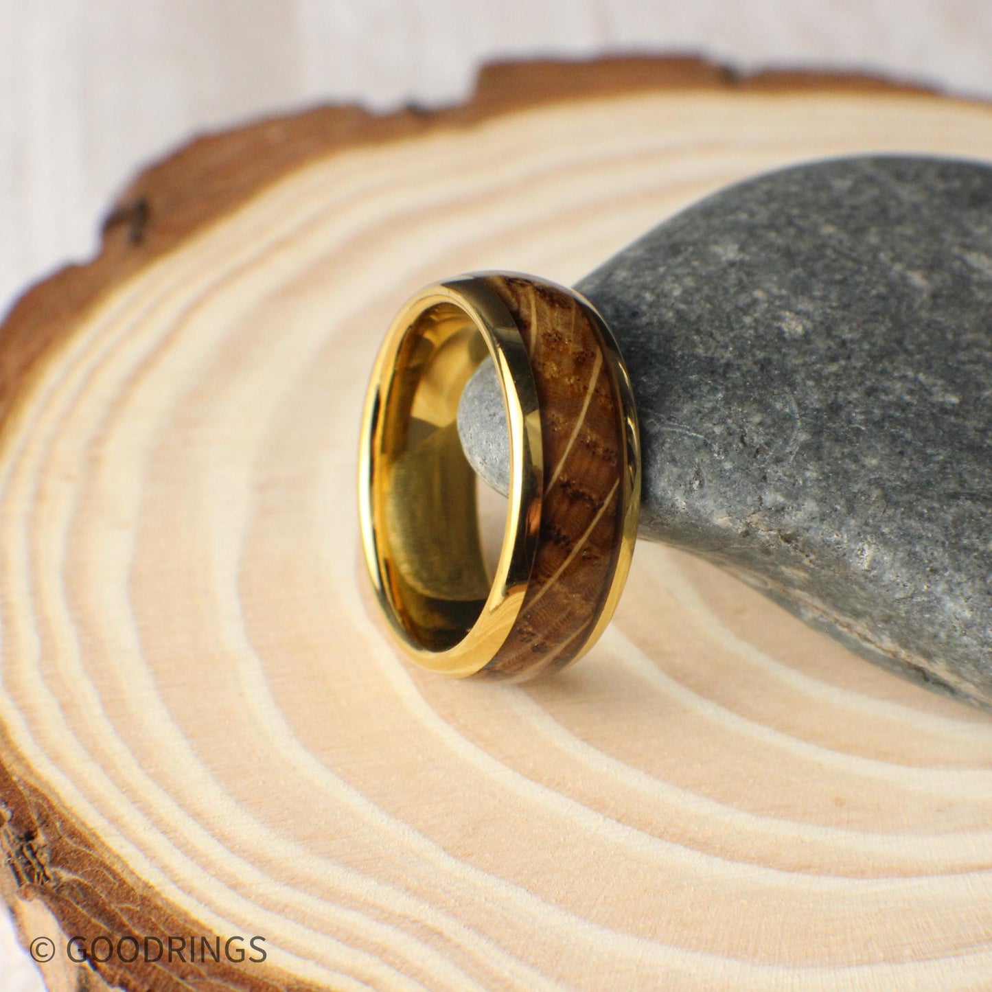 Close-up view of a domed gold men’s ring made from tungsten and whiskey barrel wood. The 8mm band highlights the beauty of the reclaimed wood with natural textures and earthy hues, sealed in a high-gloss finish that protects and shines.