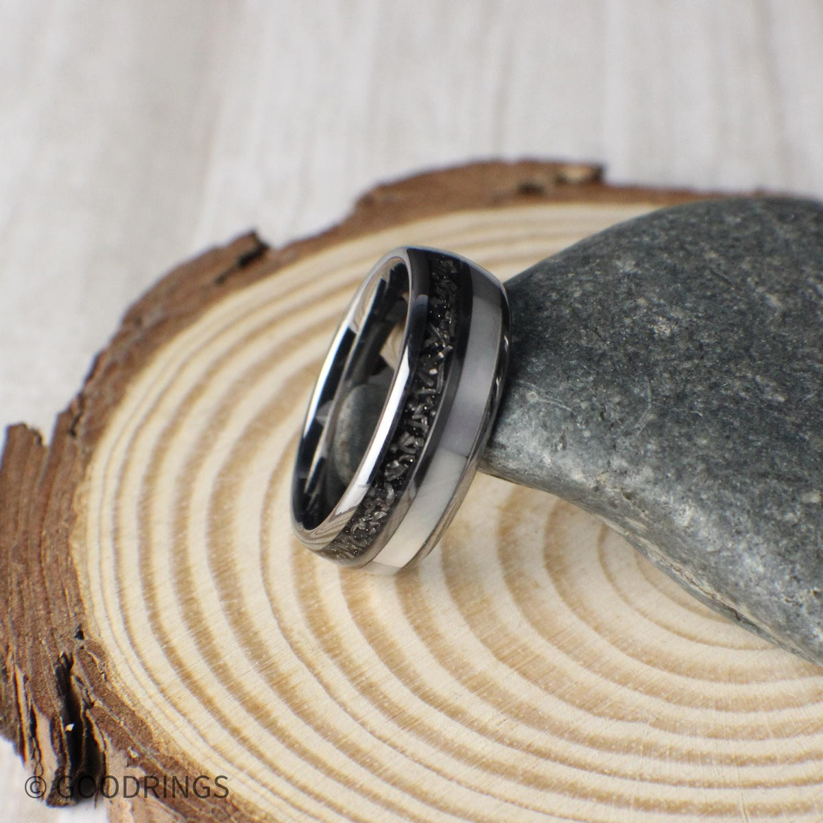 A domed tungsten men’s wedding ring crafted with meteorite and mother of pearl inlays, combining strength with sleek design. Packaged in a green GoodRings gift box.